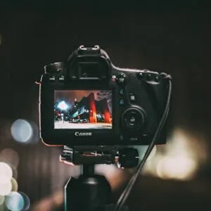 Close-up of a camera capturing a vibrant urban scene at night with a blurred bokeh background.